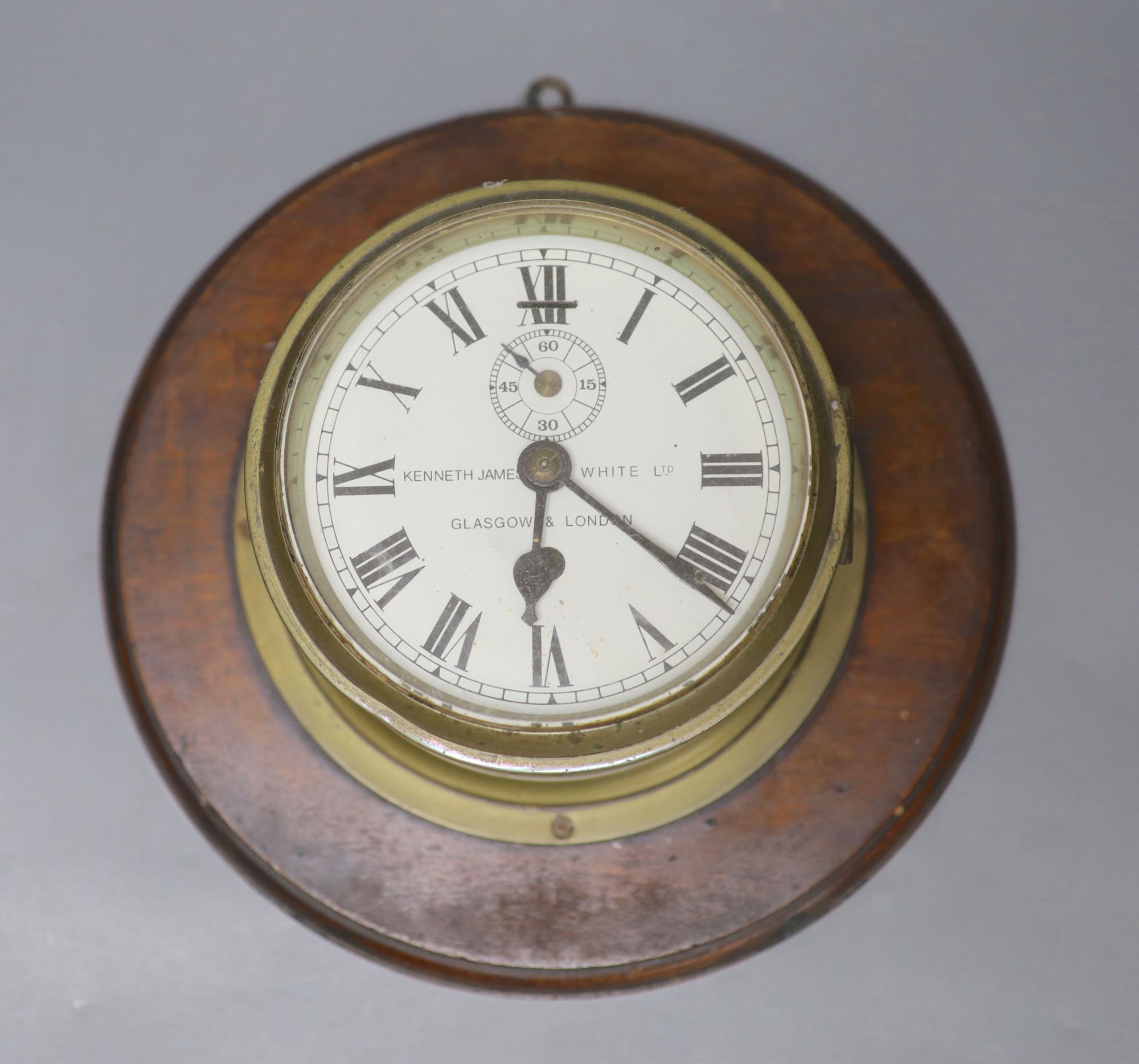 Kenneth James White Ltd., Glasgow and London. A brass cased bulkhead timepiece, mahogany mounted